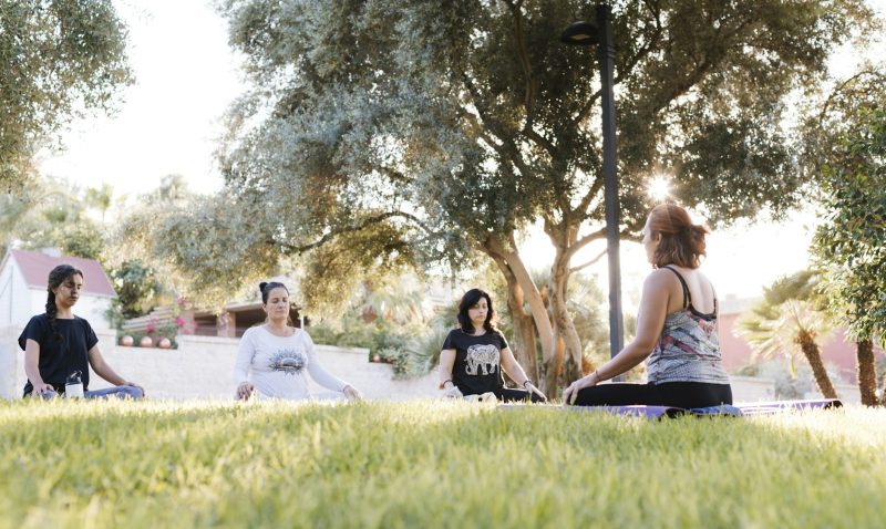 Group of women doing yoga outdoors in a park